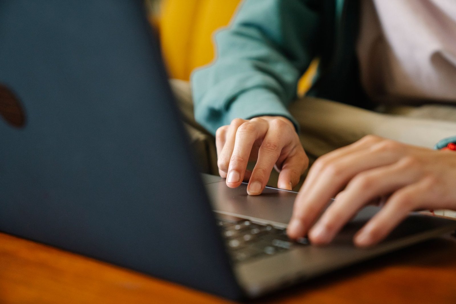 crop remote worker typing on laptop in house